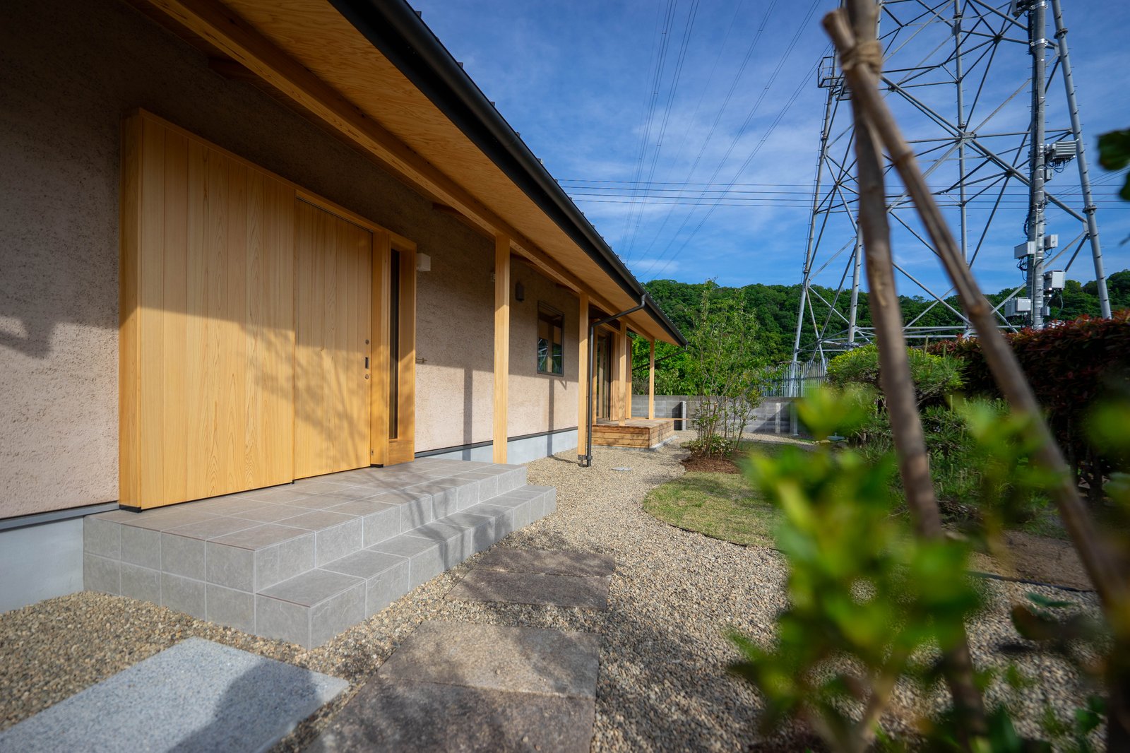 自然素材の外壁と木製建具の平屋のアプローチ